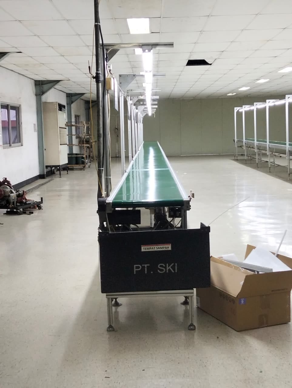Pemasangan sistem conveyor belt untuk lini produksi pabrik industri